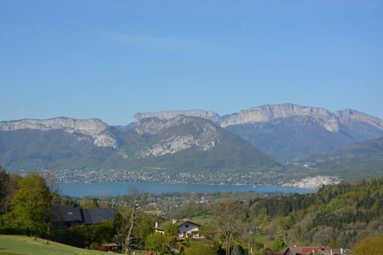 Vue panoramique lac et montagnes, jour ensoleillé.
