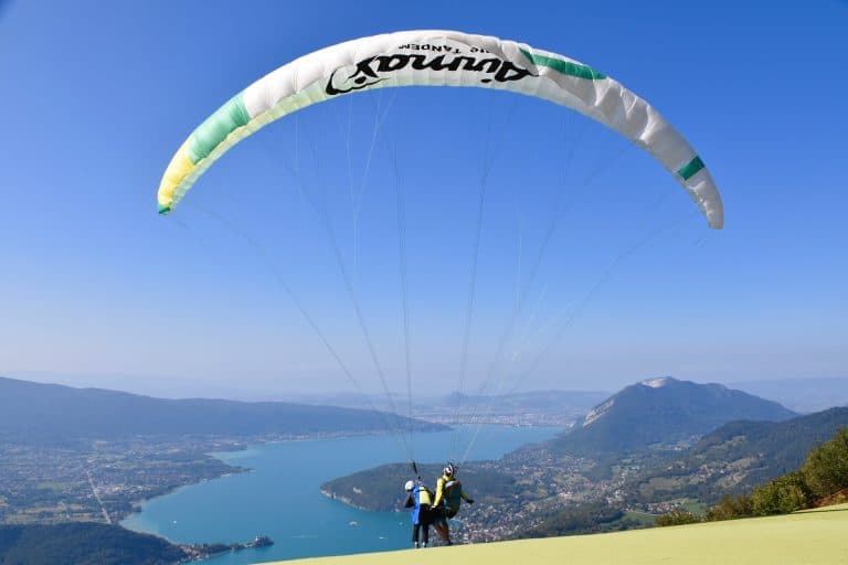Parapente au-dessus du lac et des montagnes.
