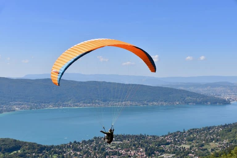 Parapente survolant un lac avec vue panoramique.